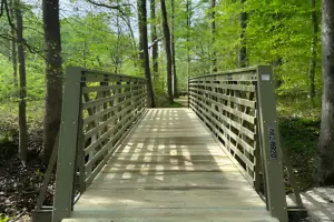 Olive green FRP truss bridge installed on the Watkins Spicebush Trail in Maryland.